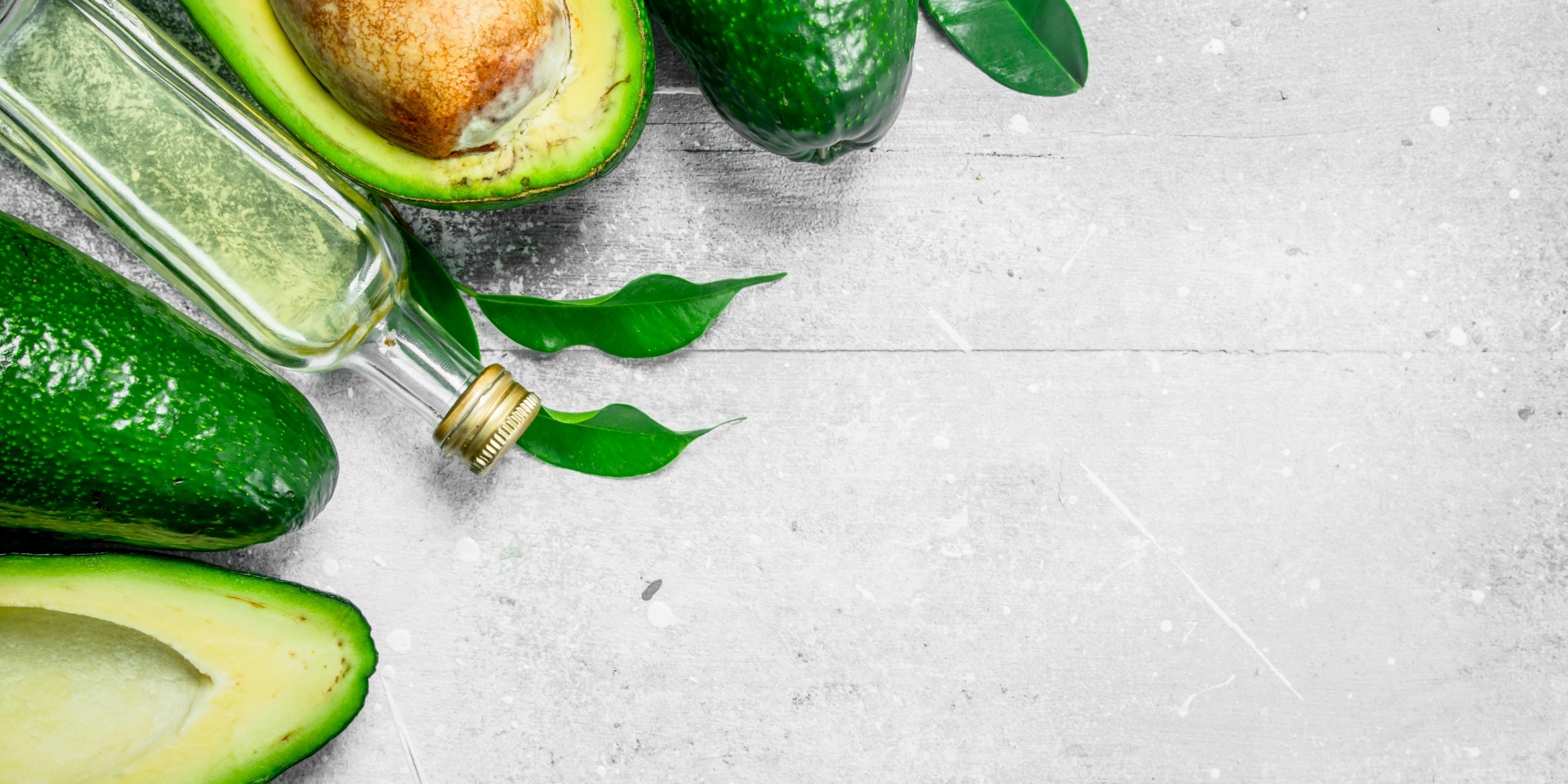 Oil bottle surrounded by avocados