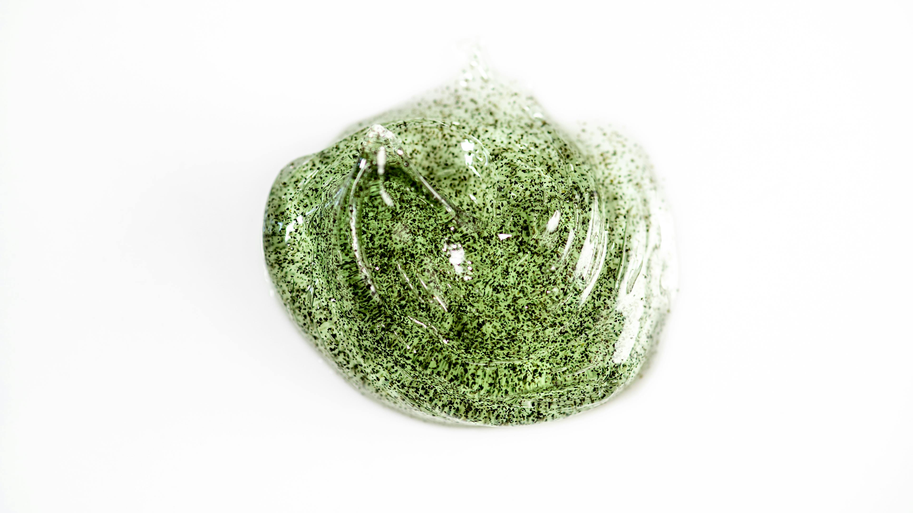 Green gel with black particles on a white background