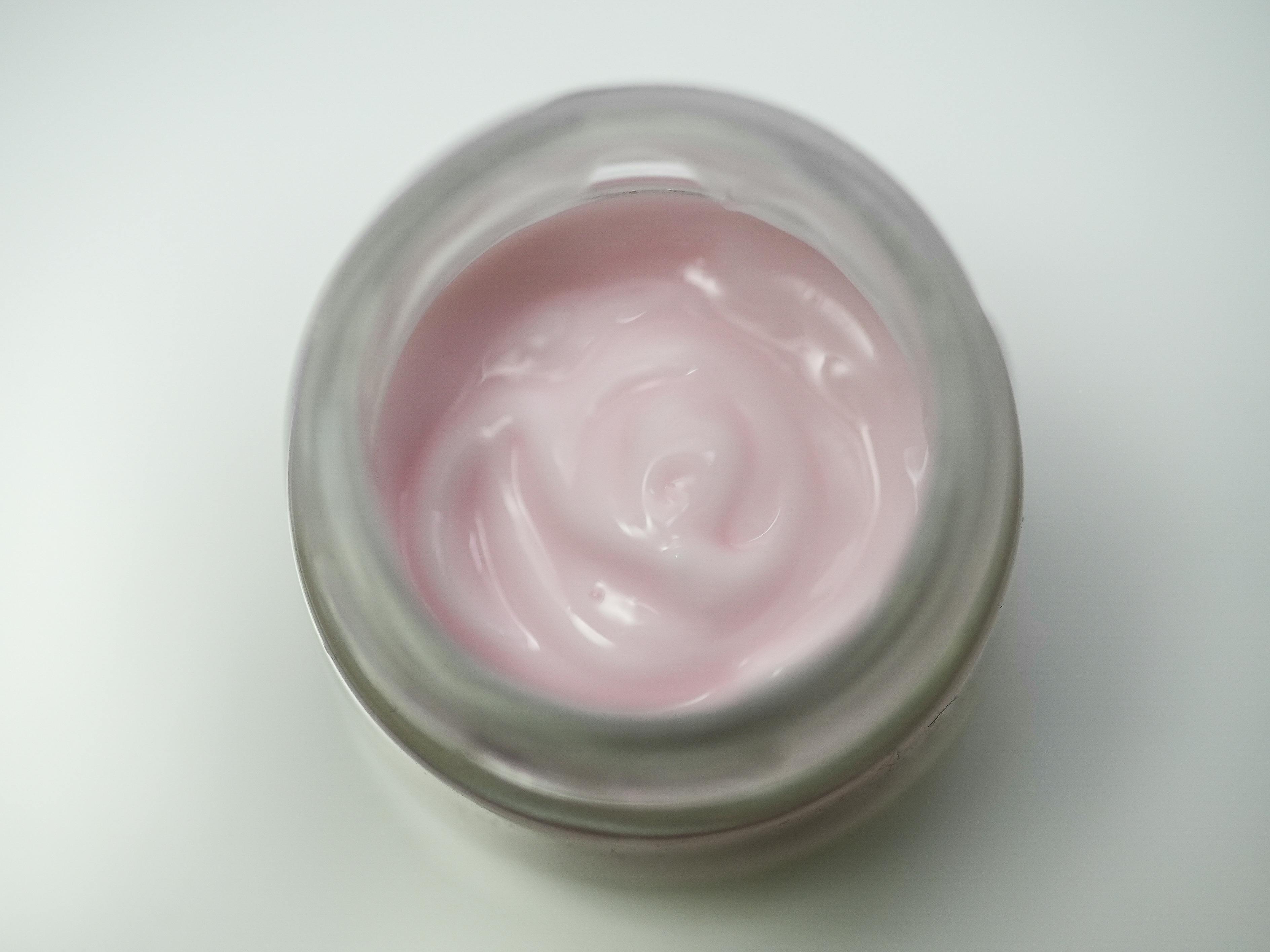 Pink cream in a jar on a white background