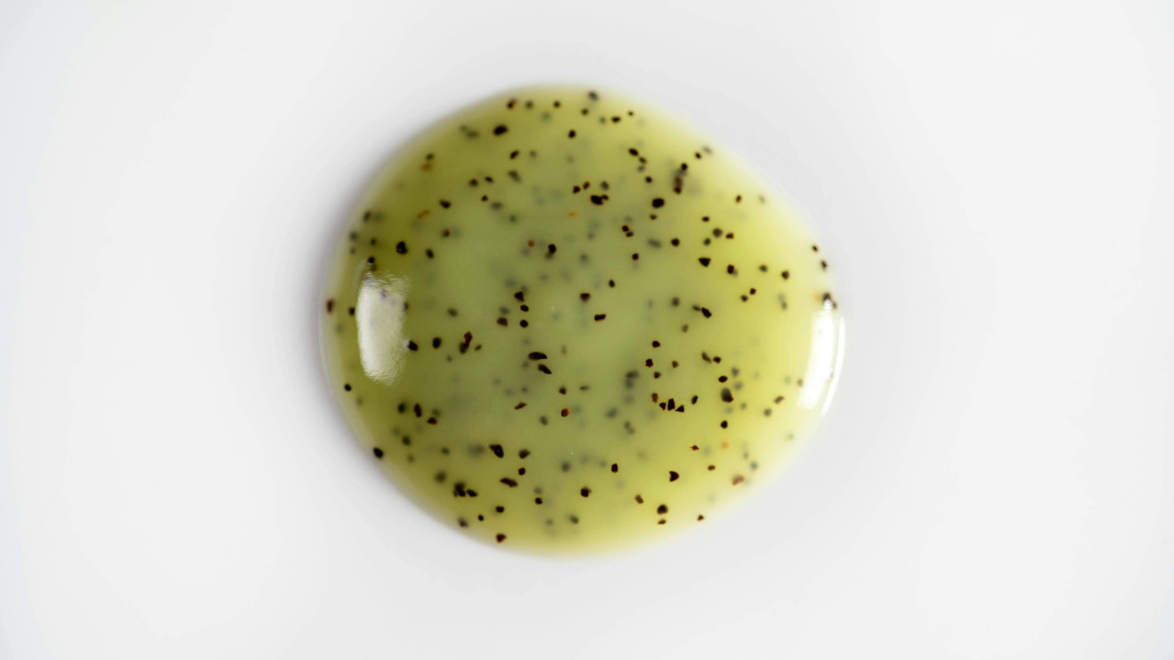 Green gel with black particles on a white background
