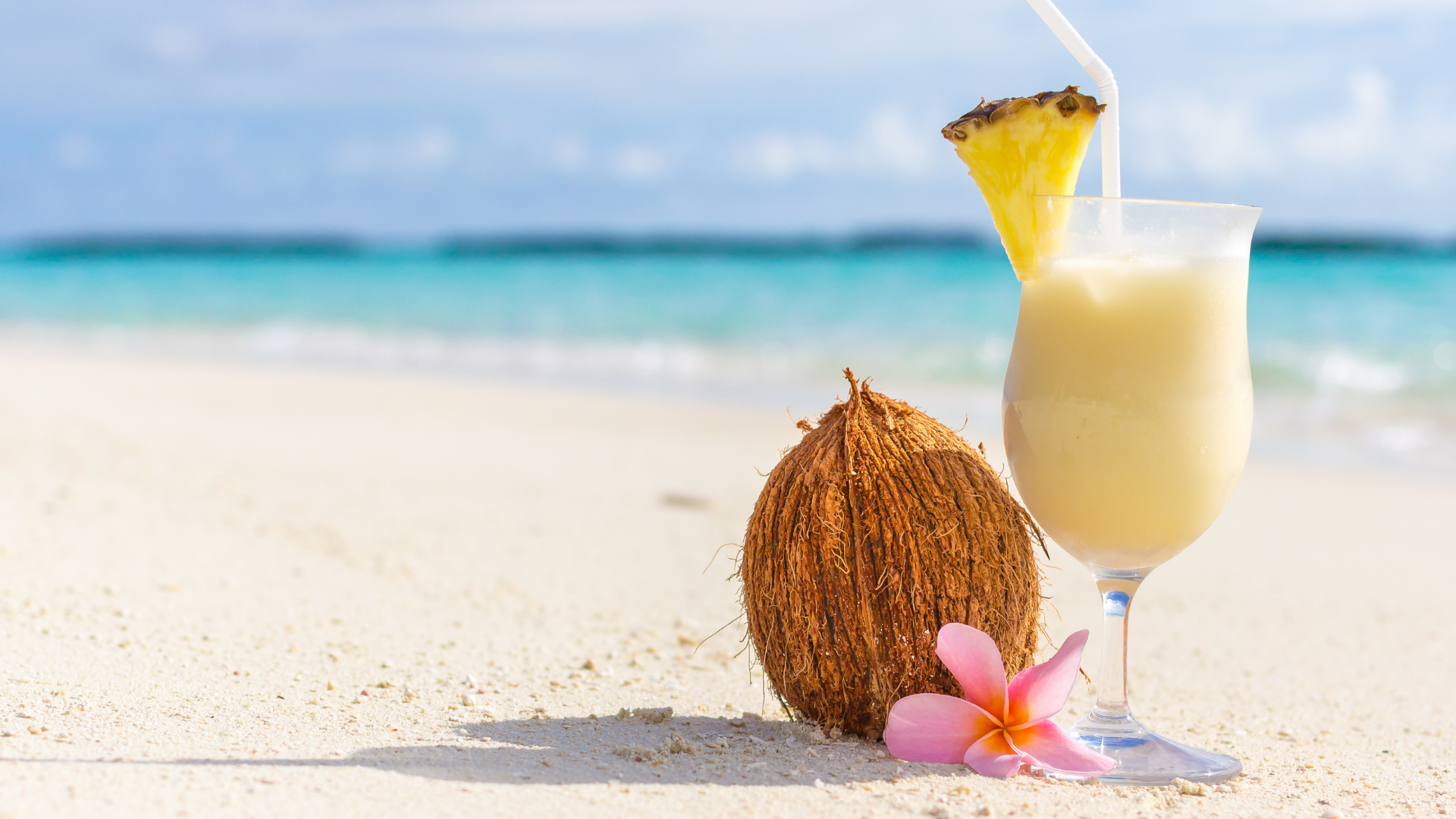 Pina colada and a coconut on a beach