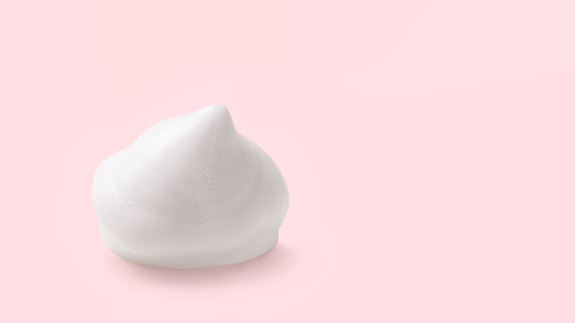 White foam on a light pink background