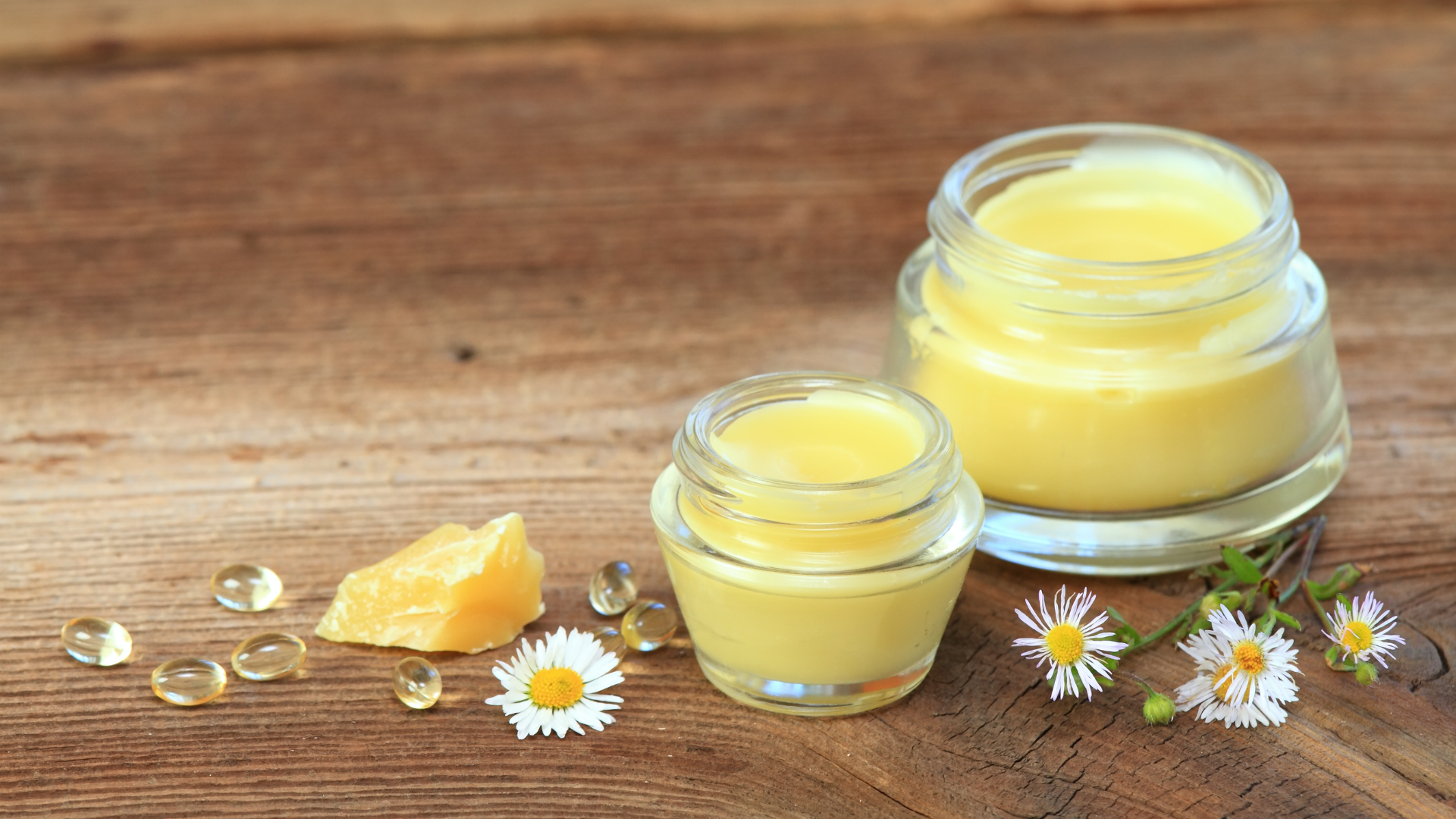 Yellow balm in a jar on a wooden background